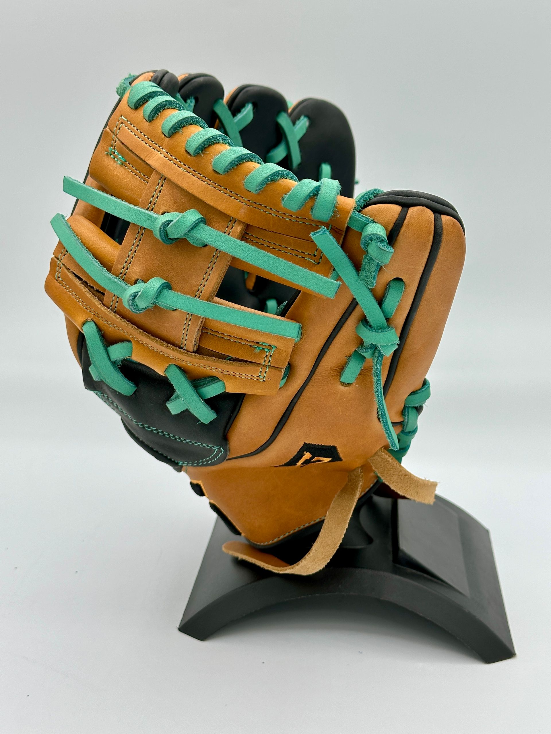 A baseball glove with green laces is on a stand