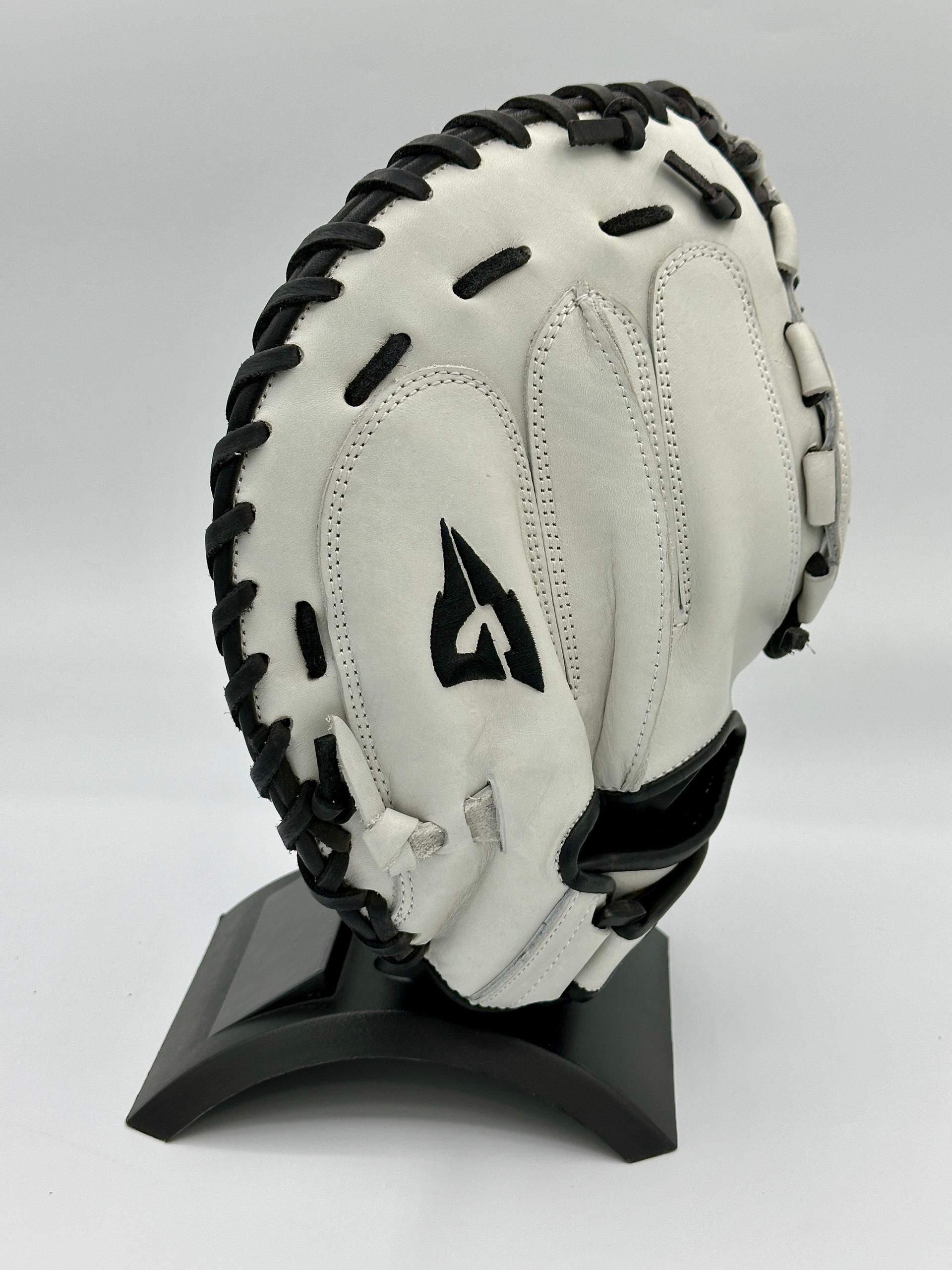 A black and white baseball glove with the letter a on it