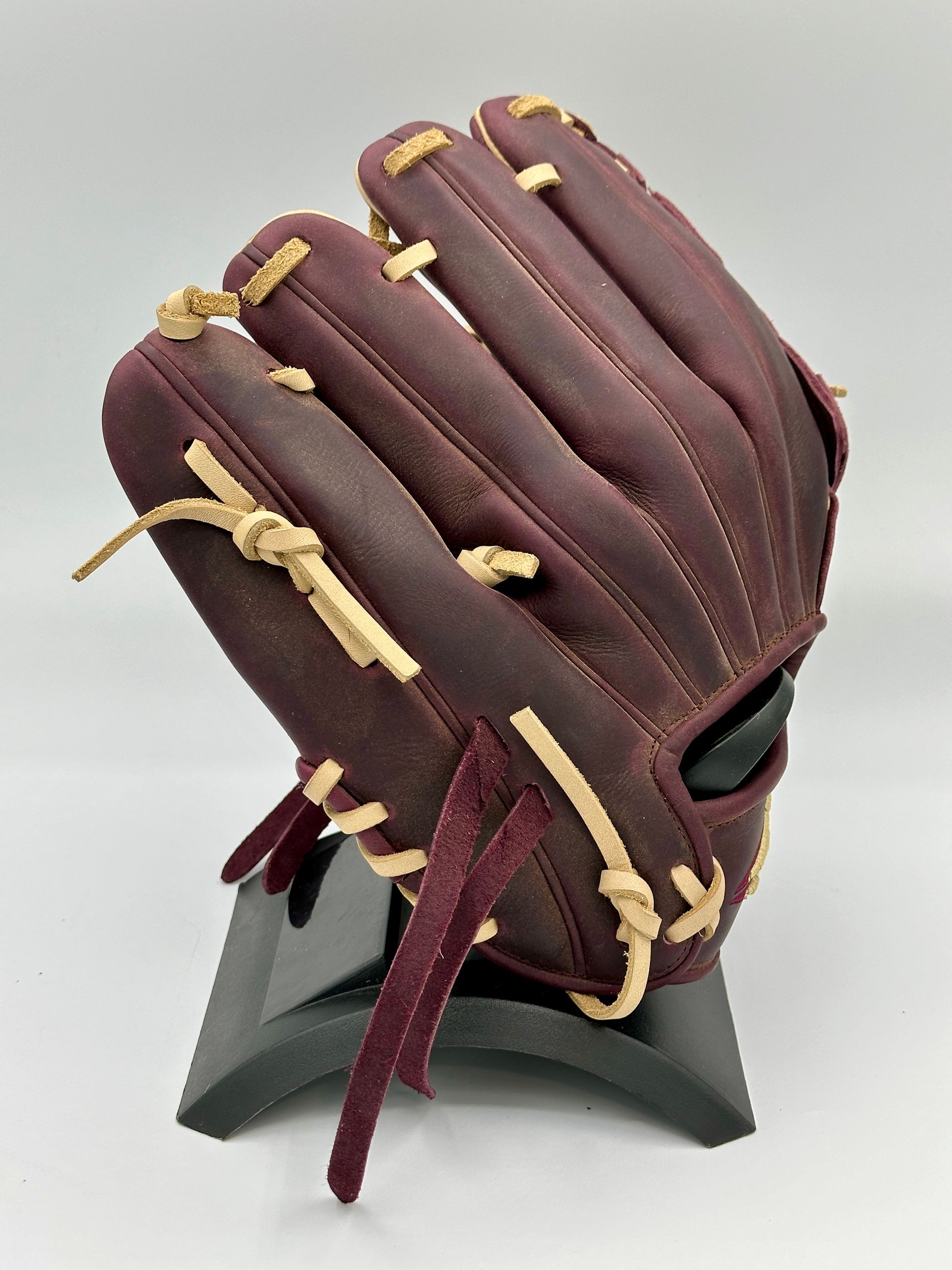 A purple baseball glove is sitting on a black stand