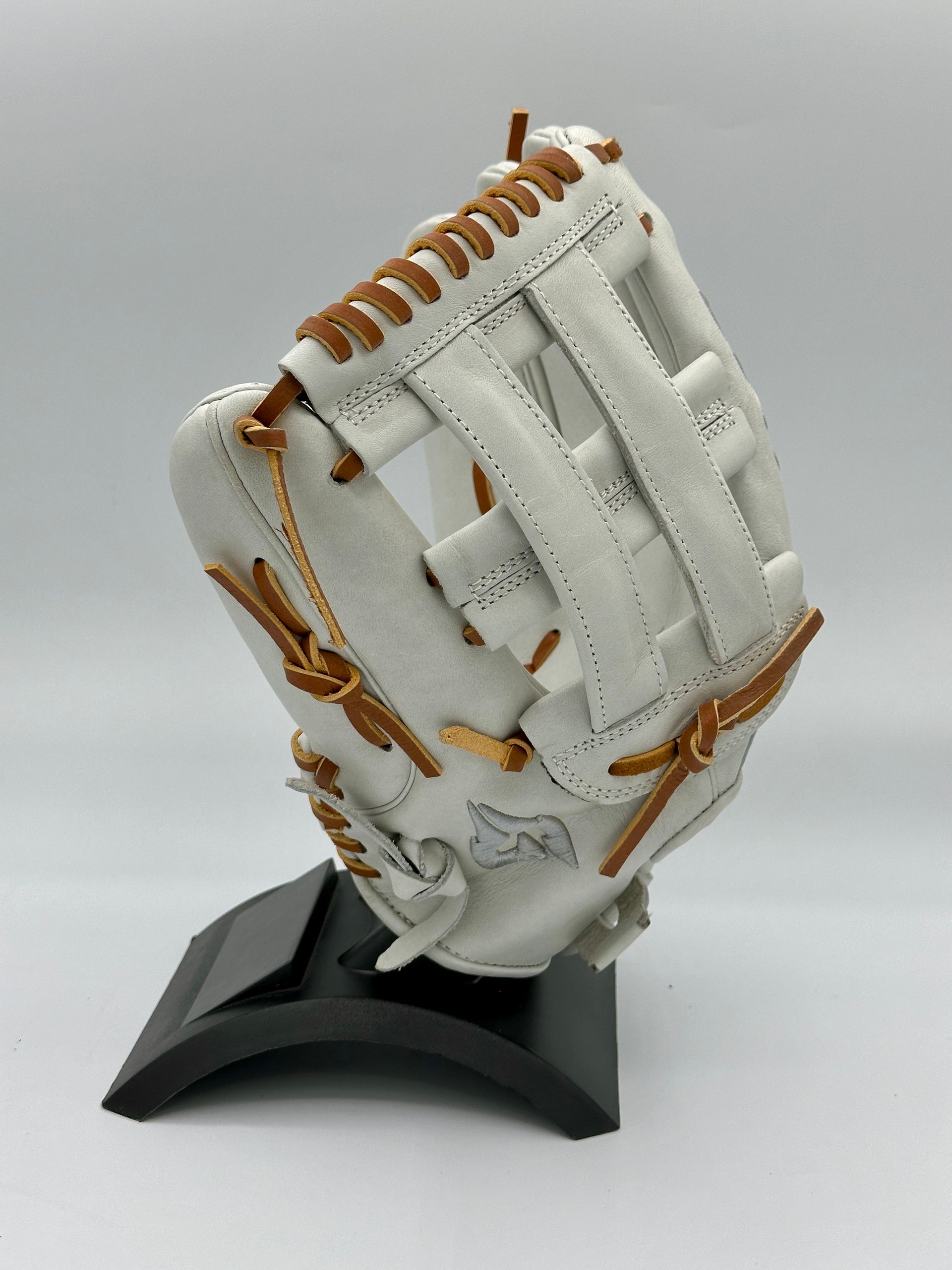 A white baseball glove is sitting on top of a black stand.
