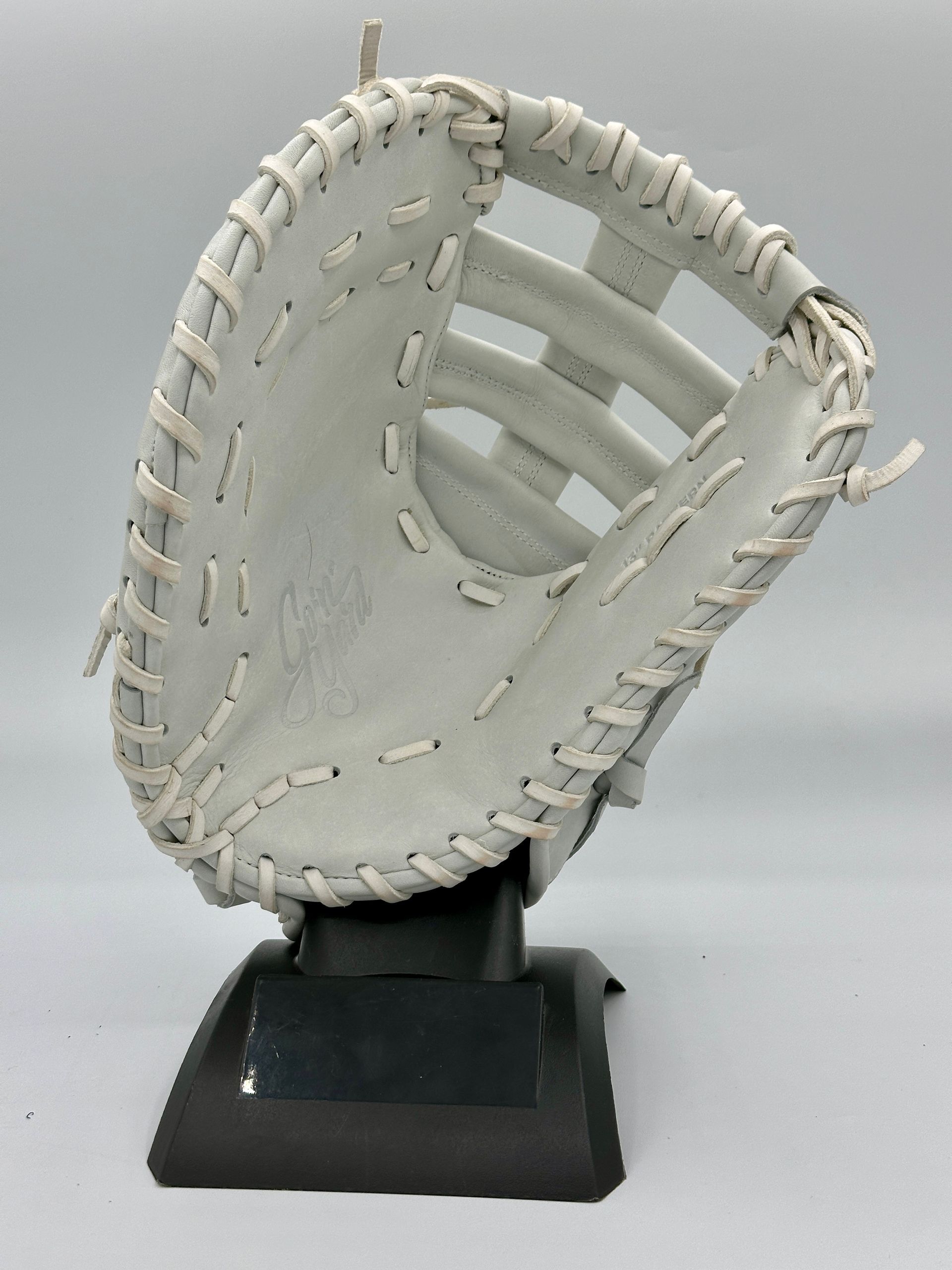 A white baseball glove is sitting on a black base