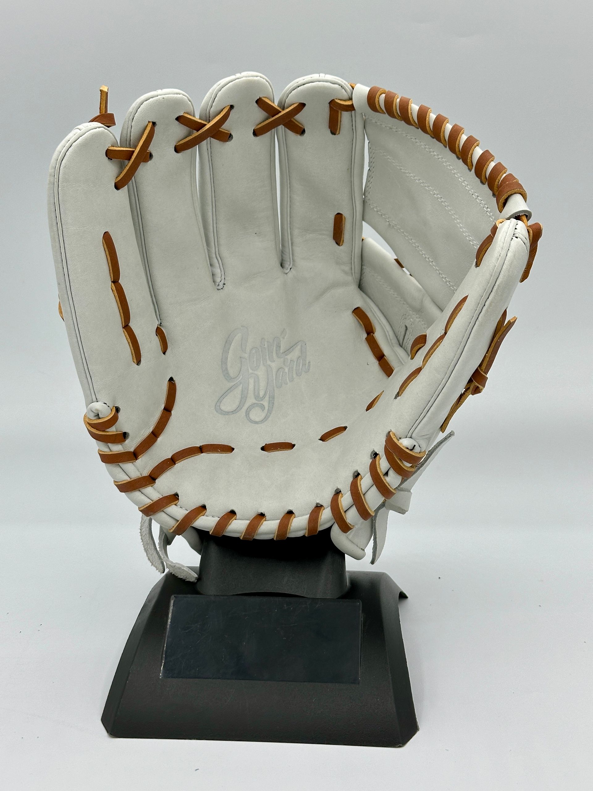 A white baseball glove is sitting on a black base
