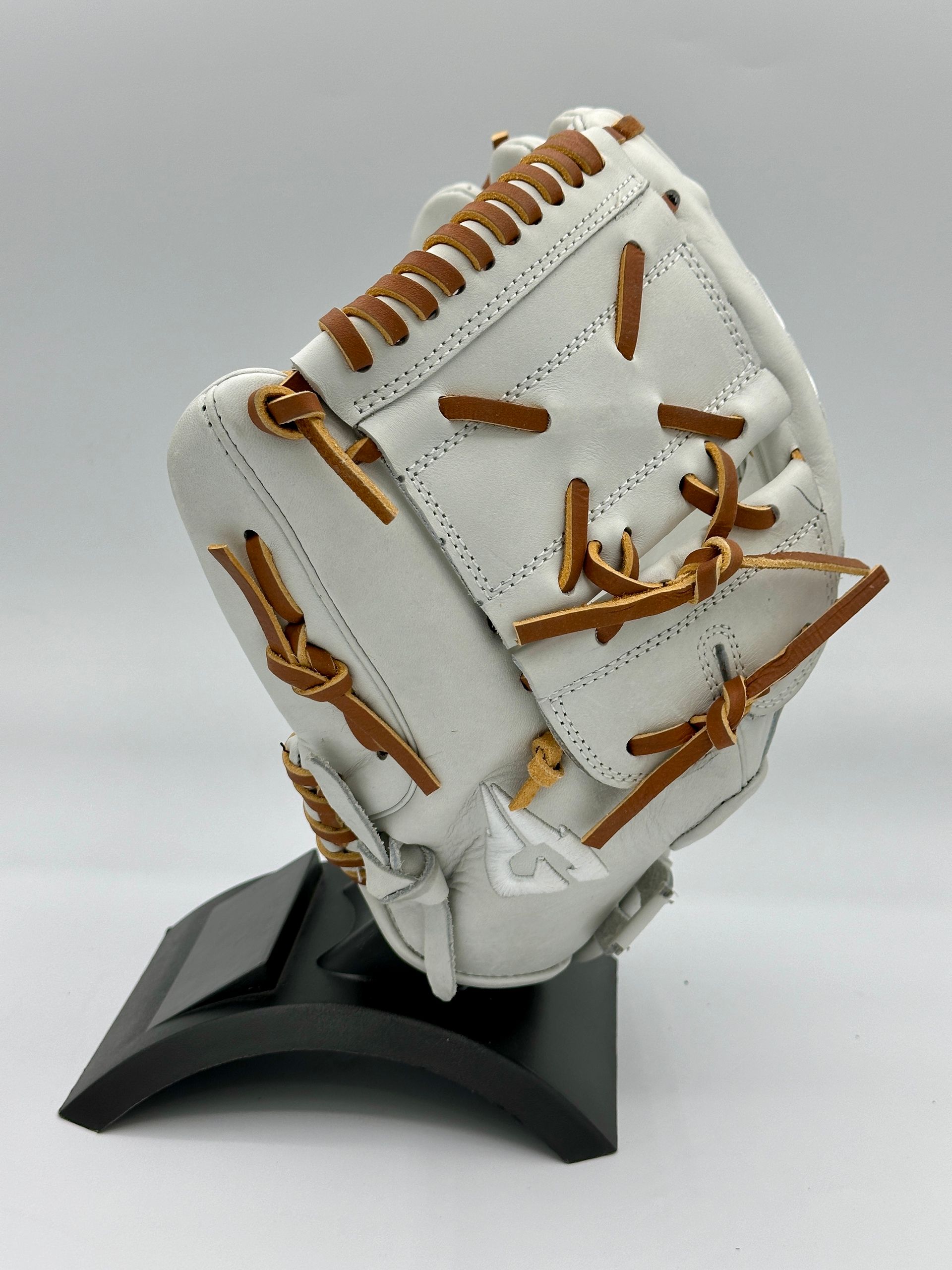 A white baseball glove is sitting on a black stand