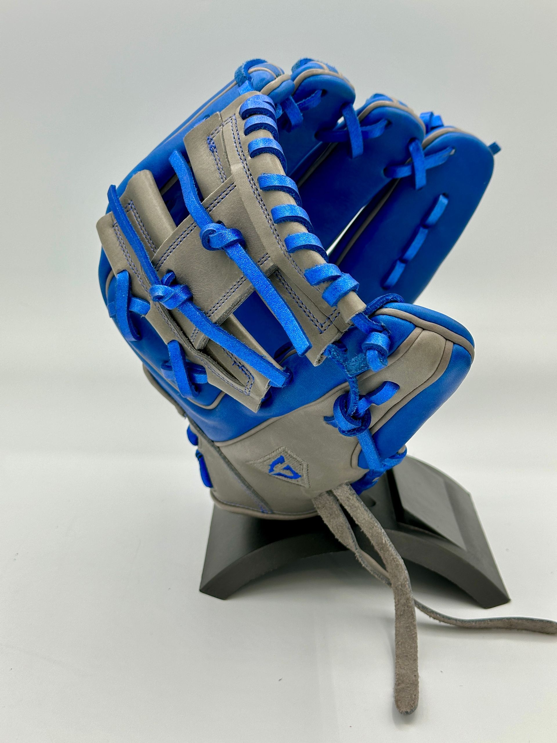 A baseball glove with blue laces is sitting on a stand