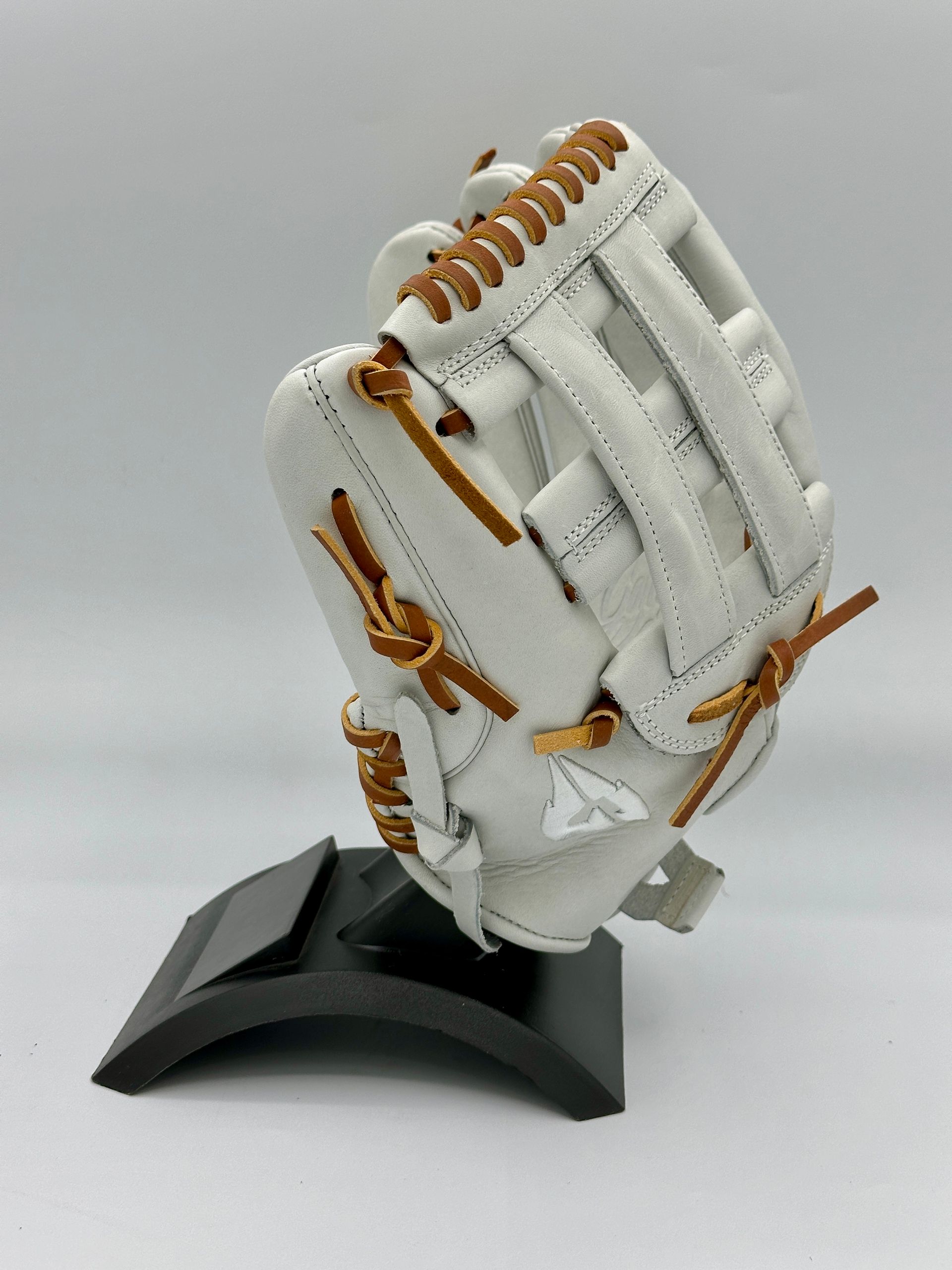 A white baseball glove is sitting on a black stand