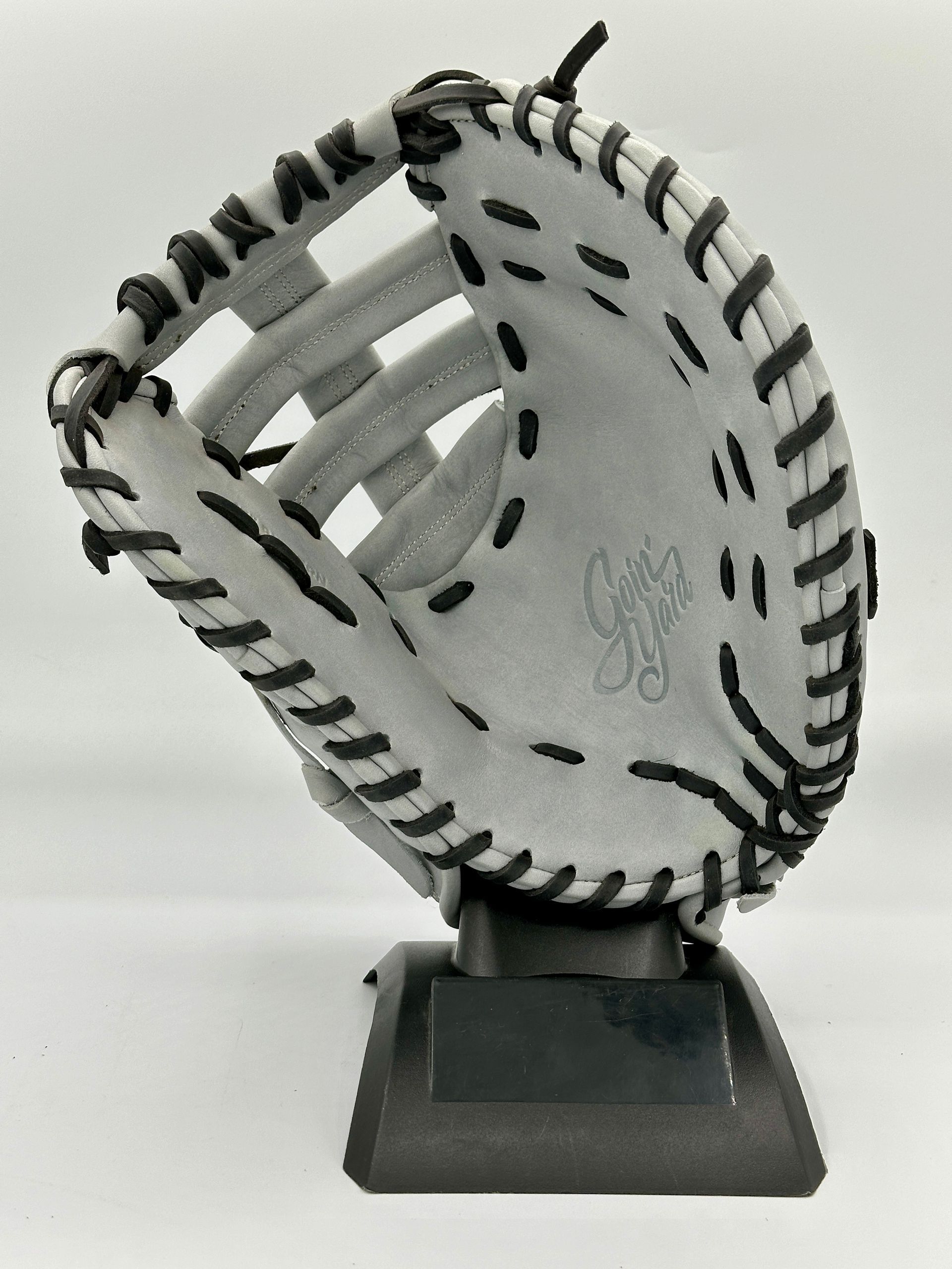 A white baseball glove is sitting on a black base