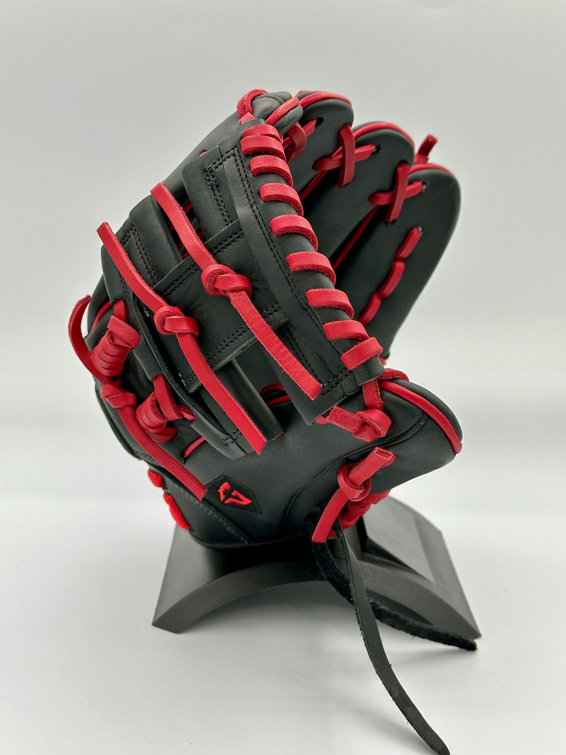 A black and red baseball glove is sitting on a stand