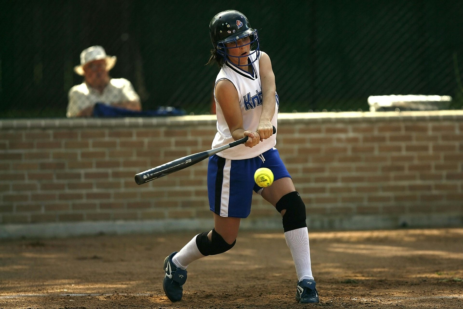 A girl is sliding into base during a softball game