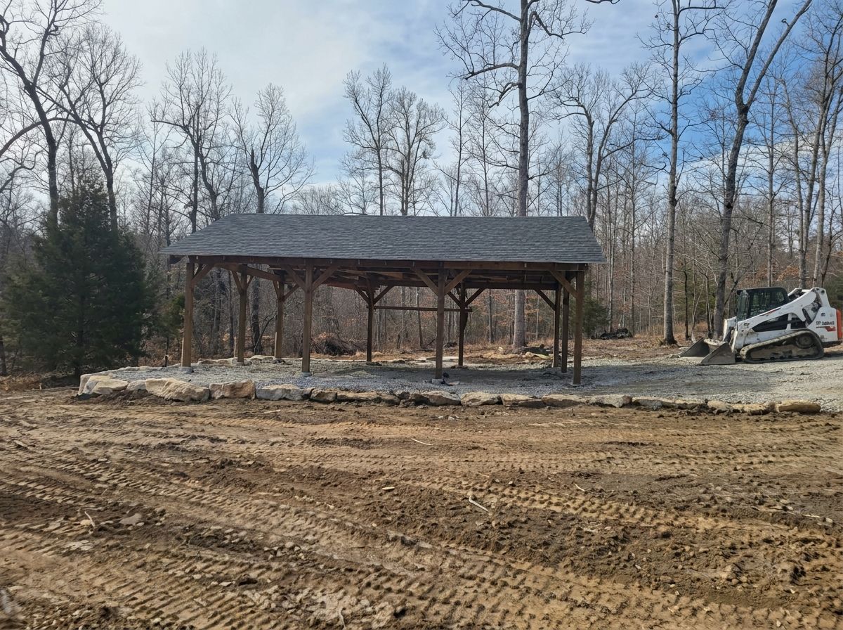 Small open-sided wooden pavilion in a leafless wooded clearing with a dirt foreground and a parked vehicle.