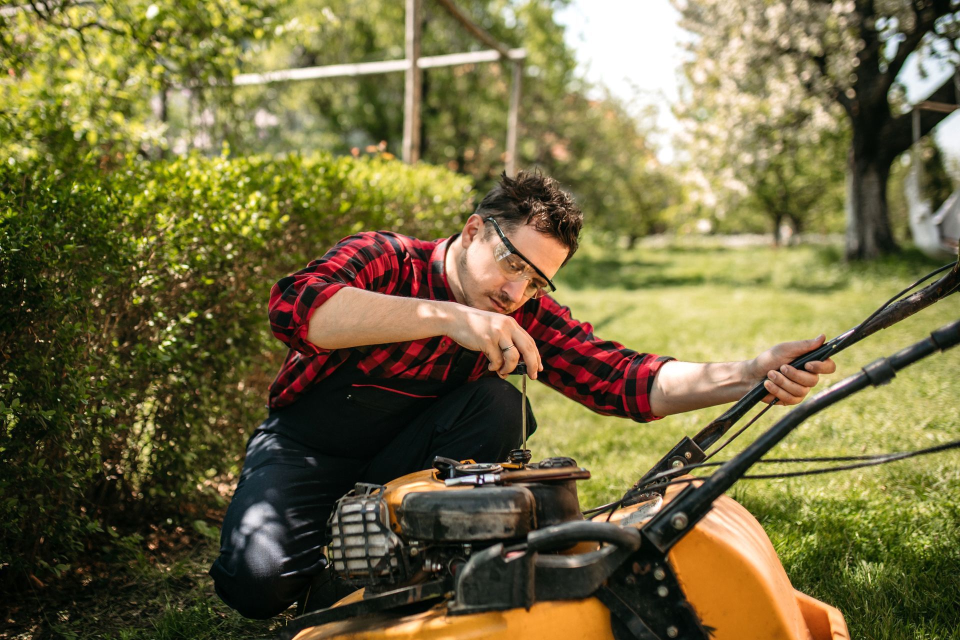 A man checking lawn mower oil.