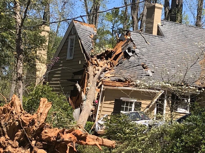 A house that has been damaged by a tree.