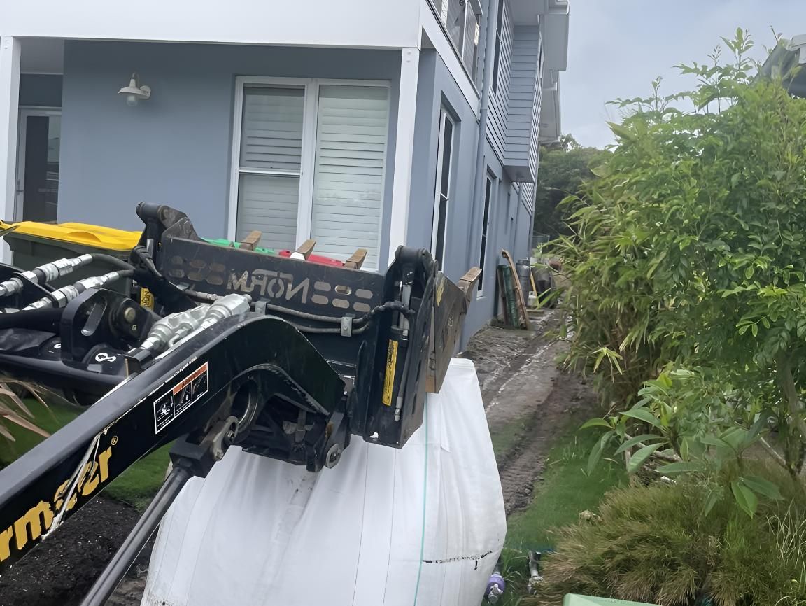 A Machine Is Lifting a Trash Bag — R&J Cronin Equipment Hire in Wyee, NSW