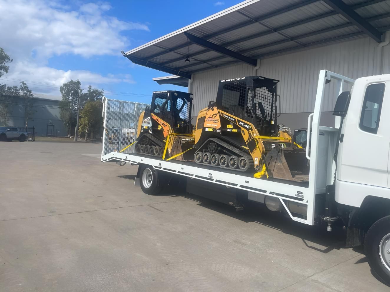 Two Bulldozers Are on The Back of a Tow Truck — R&J Cronin Equipment Hire in Cooranbong, NSW