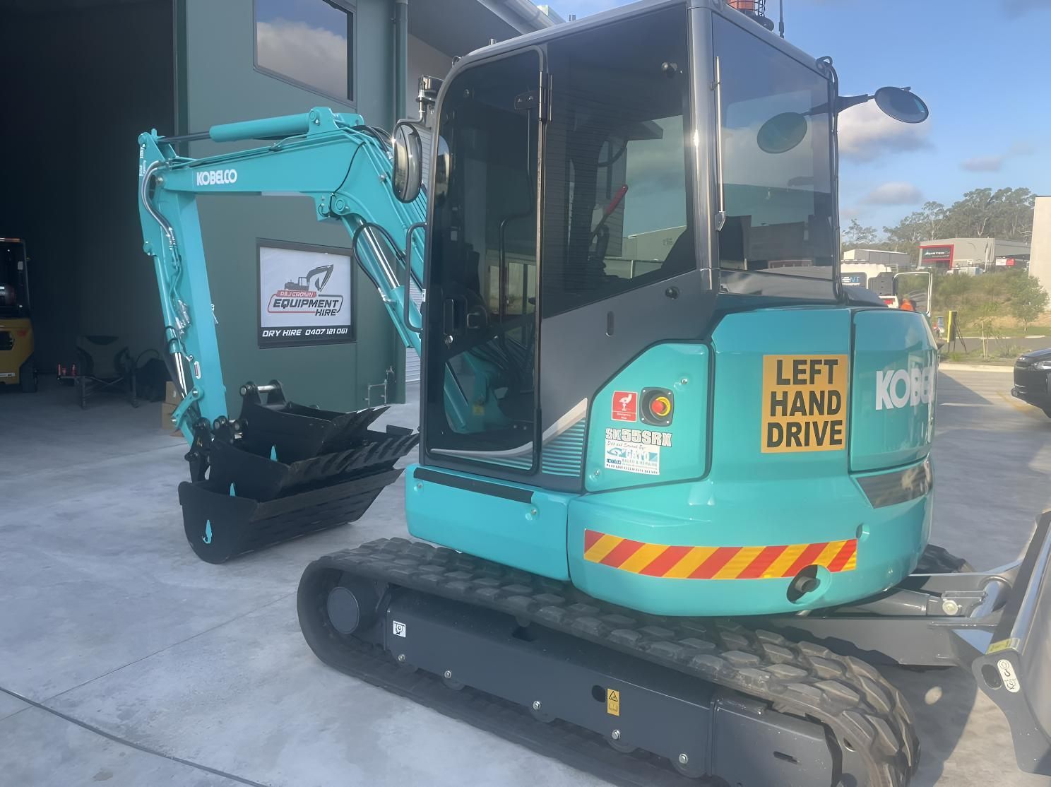 A Small Blue Excavator Is Parked — R&J Cronin Equipment Hire in Cooranbong, NSW