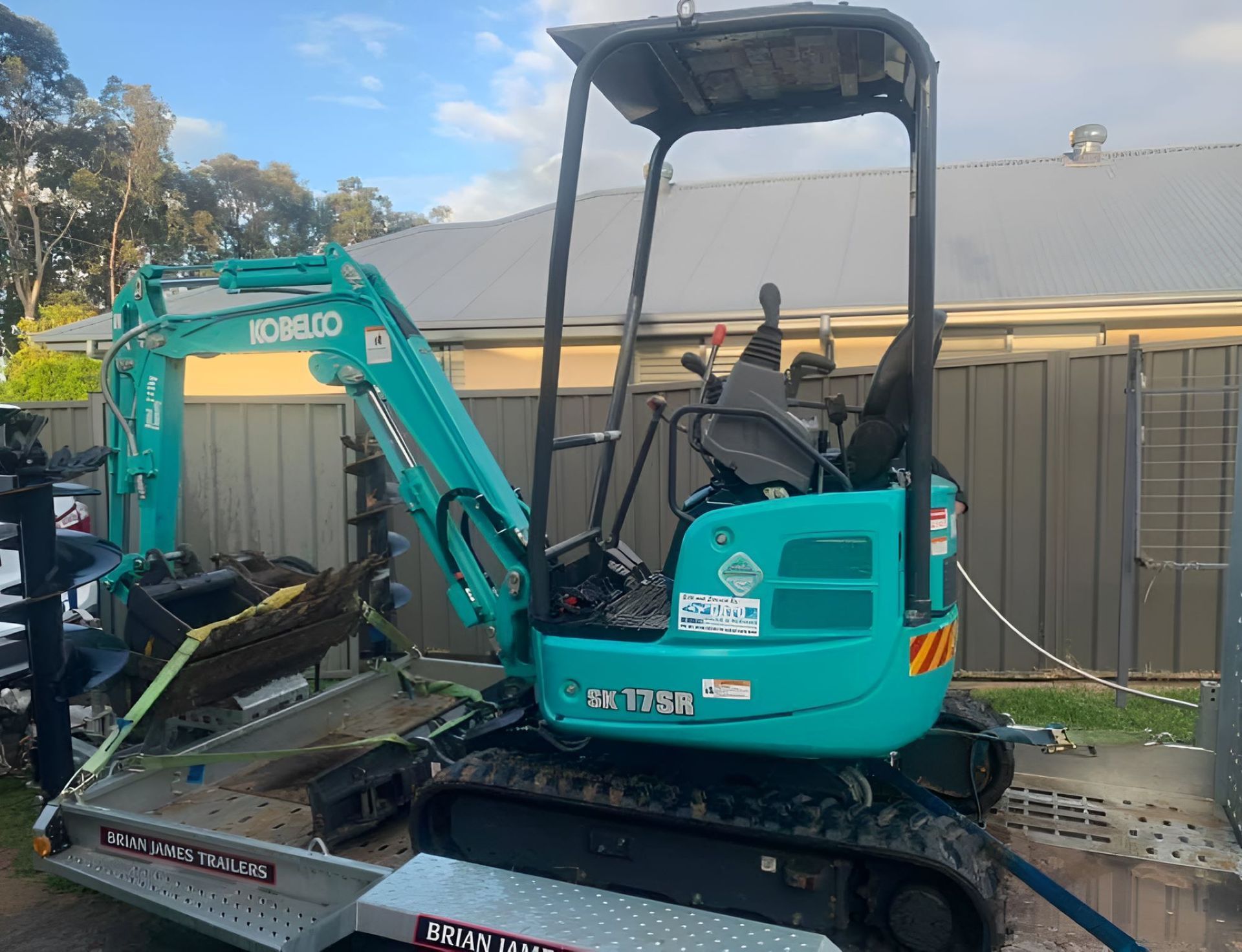 A Blue Excavator with A Yellow Sign — R&J Cronin Equipment Hire in Bonnells Bay, NSW