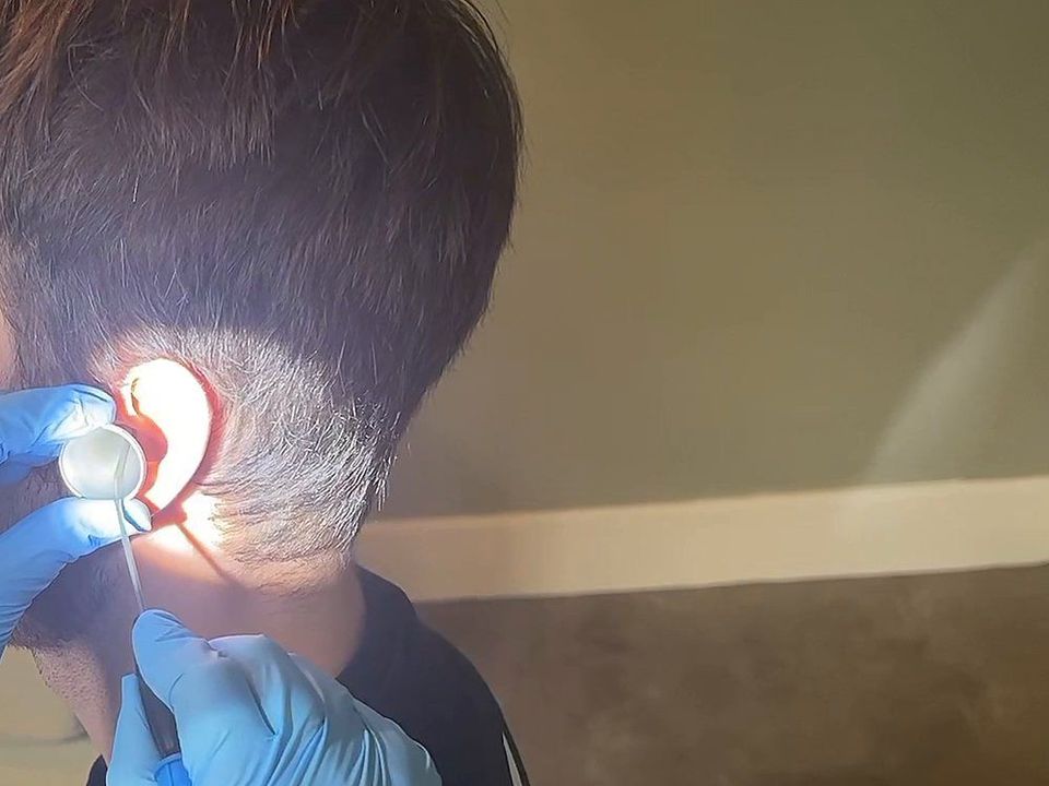 Ear microsuction under a headlight at Happy Ears in Woodthorpe, with a speculum held in the ear