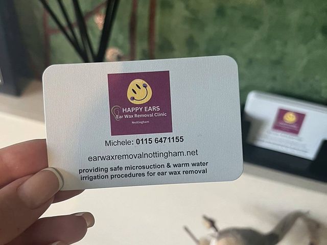 Michele's Happy Ears business card with the clinic phone number
