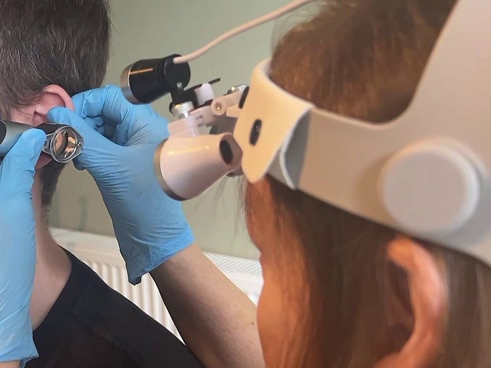Michele, wearing magnifying loupes, checks a patient's ear at Happy Ears in Woodthorpe before removing any wax