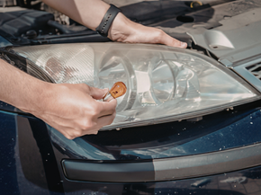 Hands polishing a car headlight with a cloth and wax applicator Person polishing a car headlight with a cloth and cleaning tool