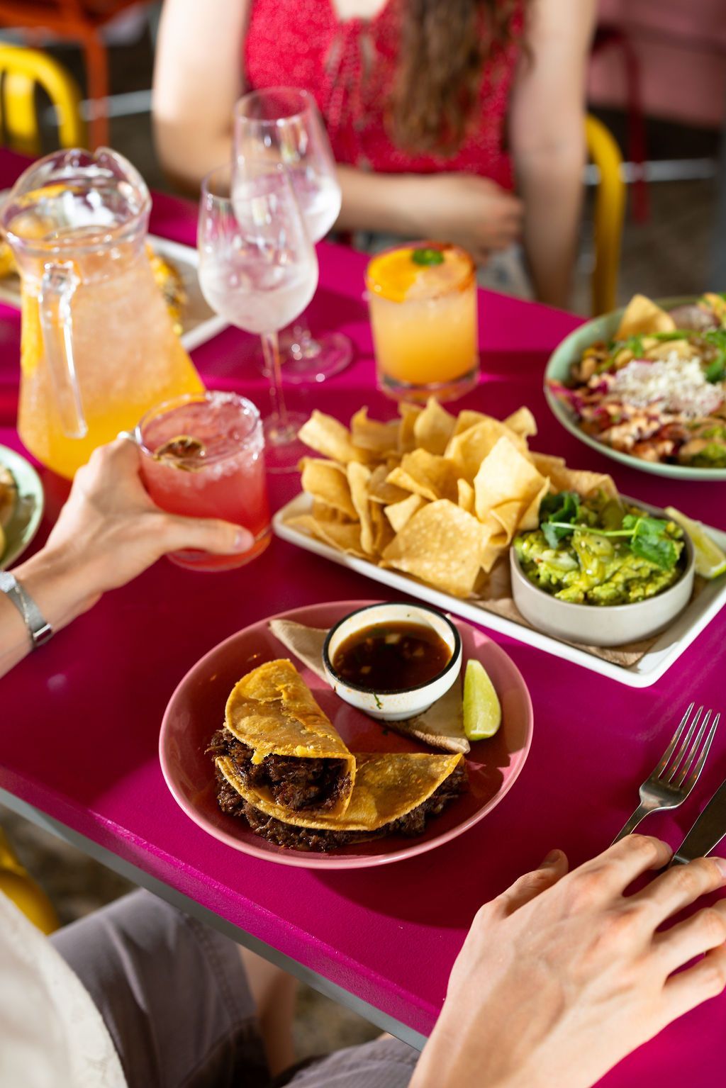 Colorful tacos on patterned plates with lime and skull decoration.