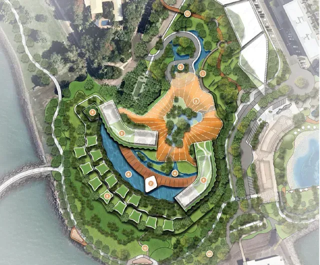 Aerial view of a coastal resort with buildings and green spaces in shades of blue, orange, and green.