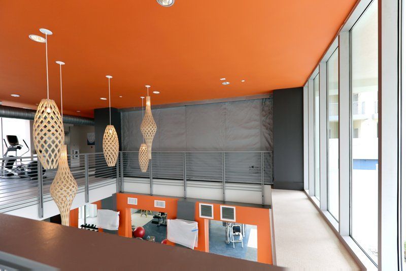 A gym with an orange ceiling and lots of windows