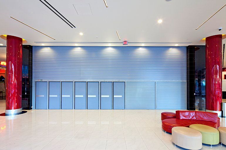An empty lobby with a blue wall and red pillars