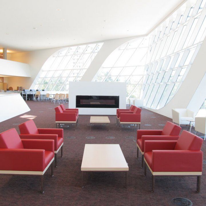 A living room with red chairs and a fireplace