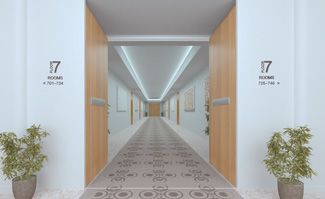 A long hallway with two potted plants on the side of it.