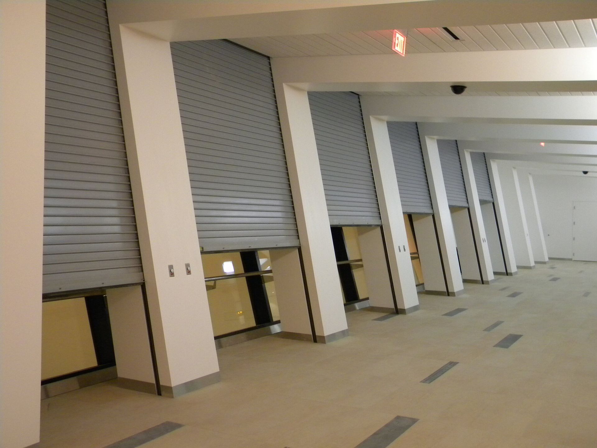 A row of roller shutters are open in a building
