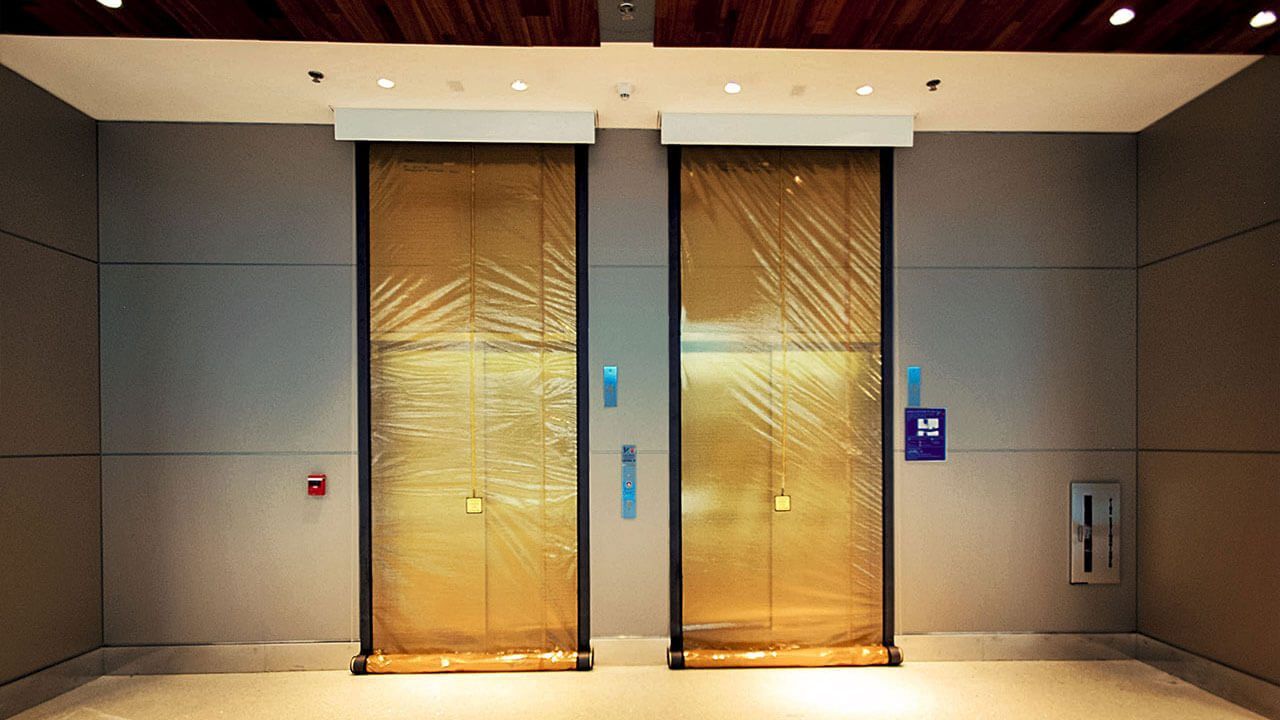 Two gold elevators are sitting next to each other in a building.