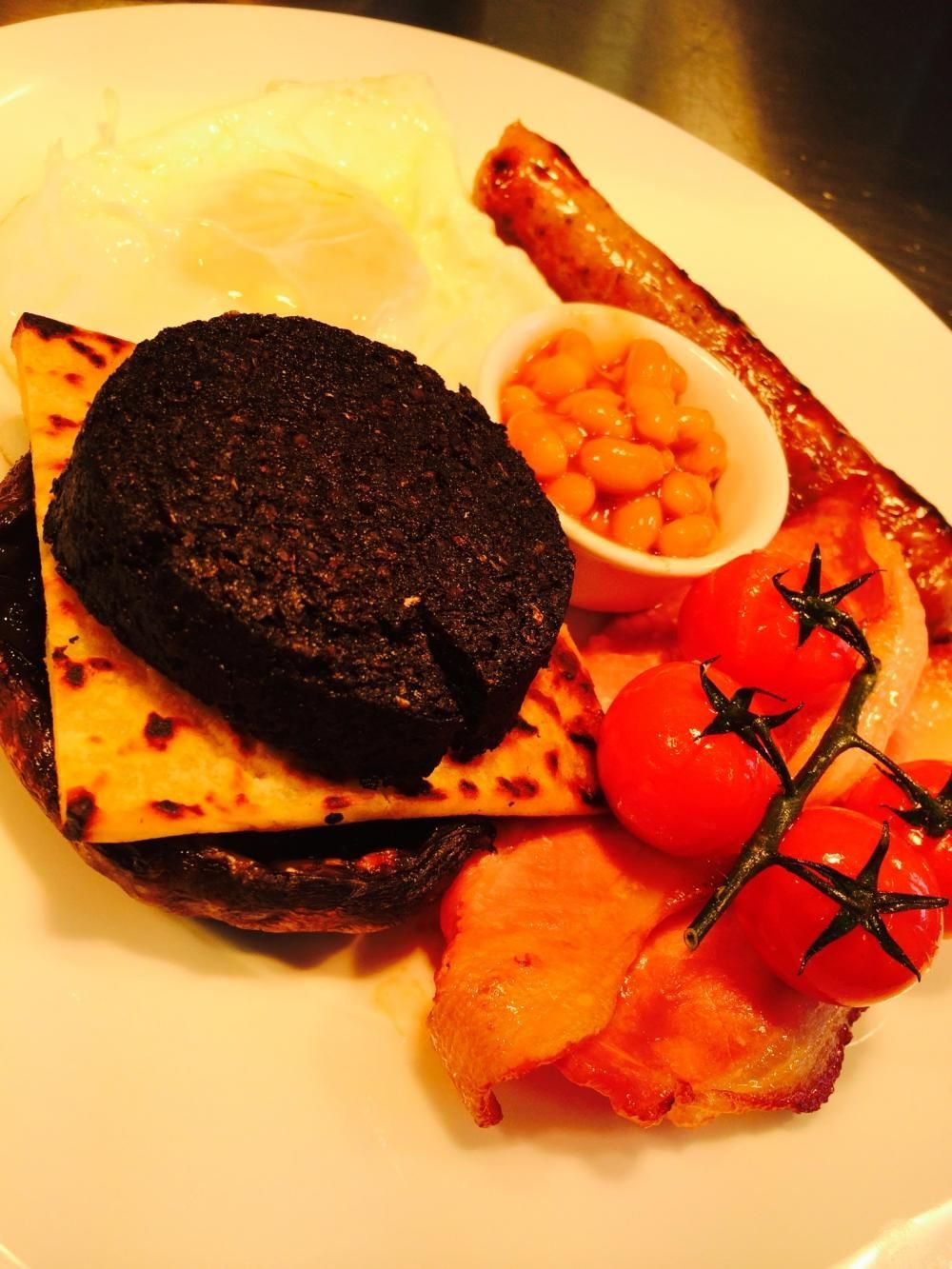Plated gourmet breakfast with black pudding, tatty scone, baked beans, eggs, tomatoes, and toast. One of the best breakfasts in Perthshire
