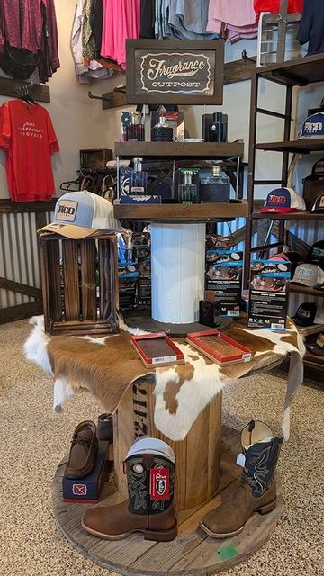 Four western belts with silver buckles and turquoise accents hang on a rack.