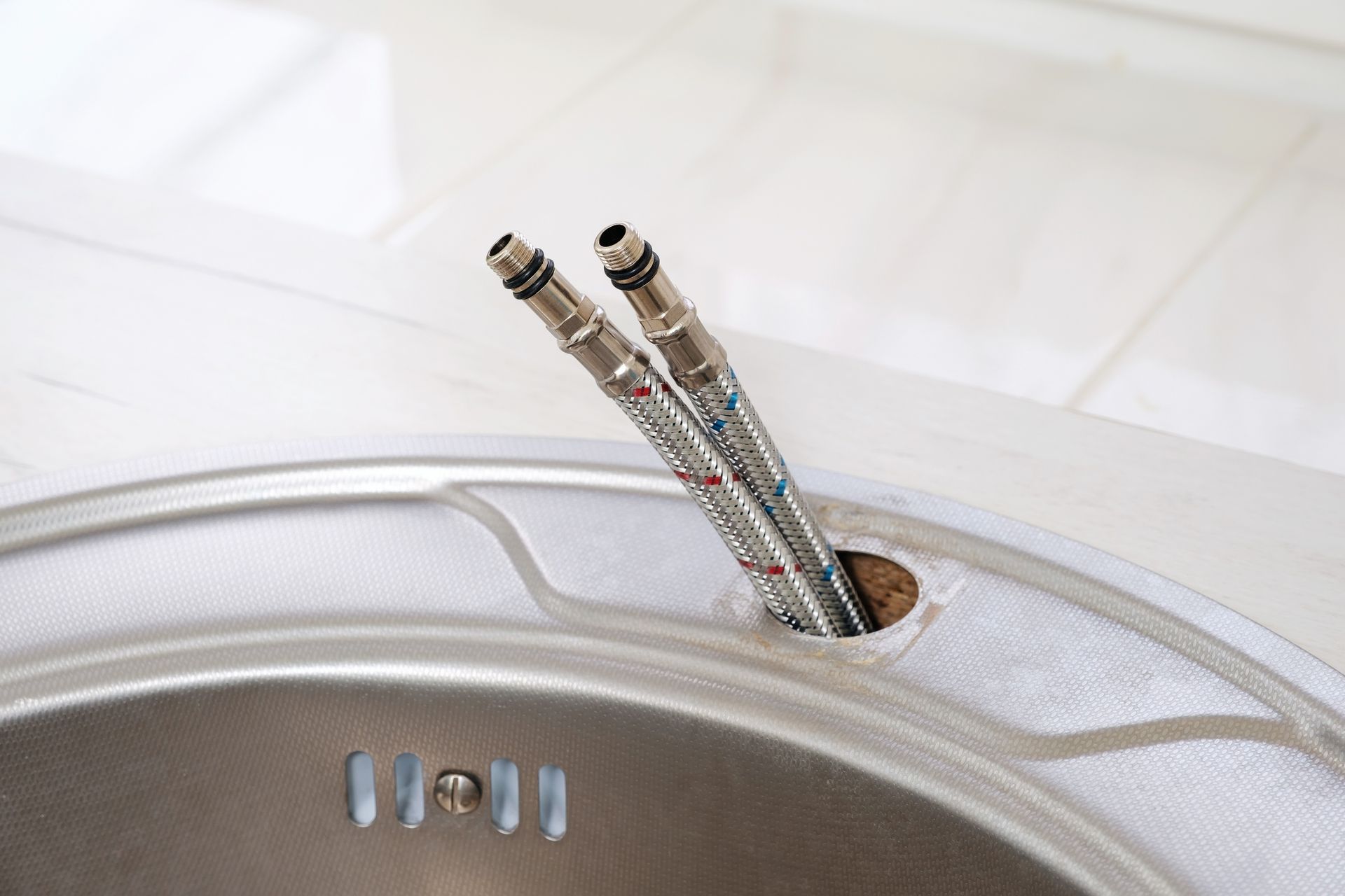 Two audio cables plugged into a silver device on a white surface