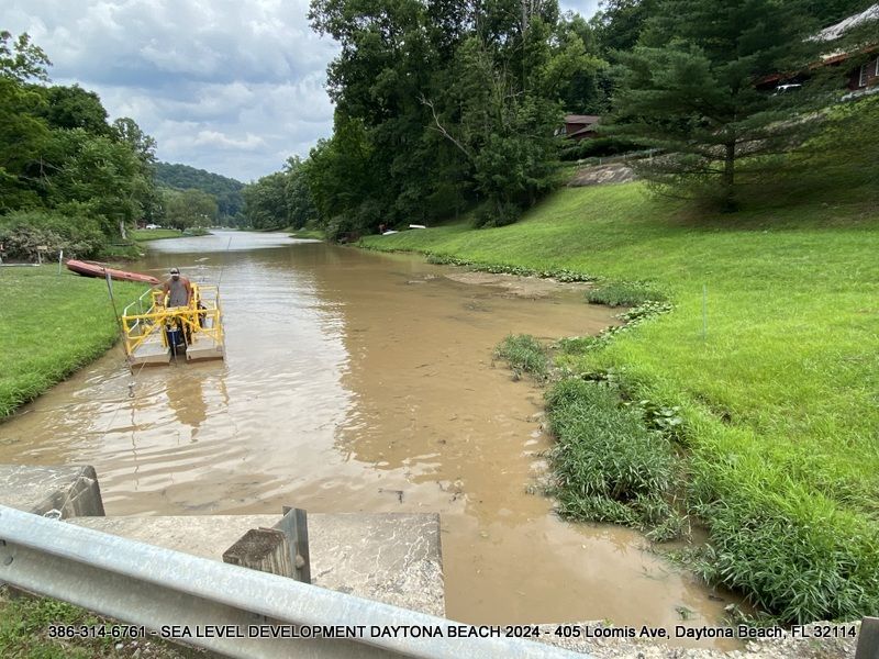 A flooded river with a boat in the middle of it