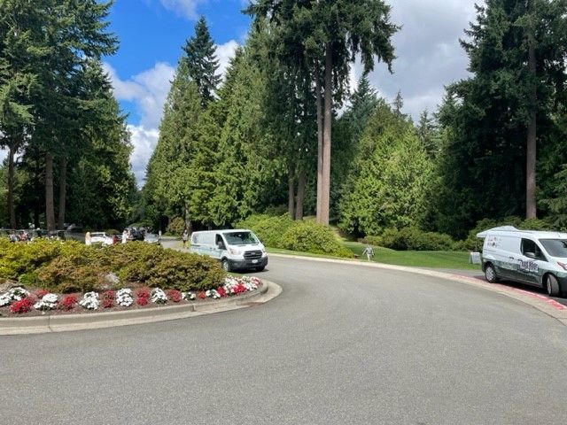 two white vans are parked on the side of the road
