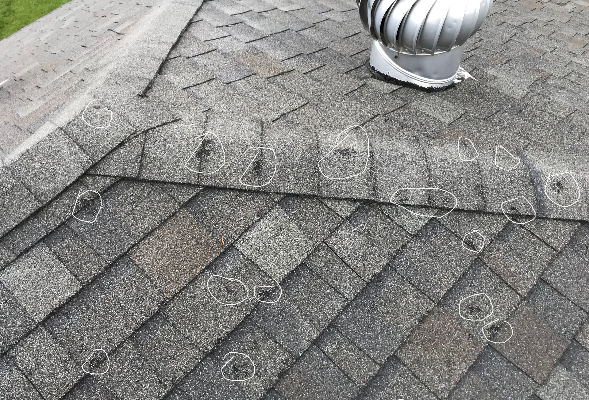 circles on a roof showing hail damage