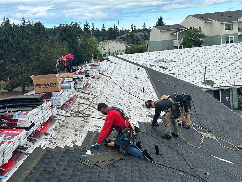 a group of men are working on the roof of a building .