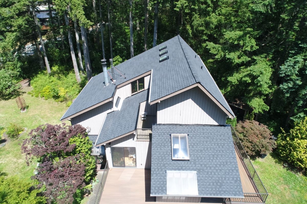 an aerial view of a house in the middle of a forest