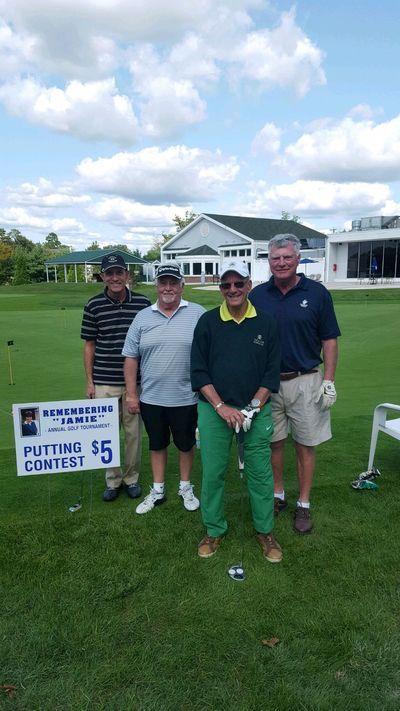 a group of men are posing for a picture on a golf course .