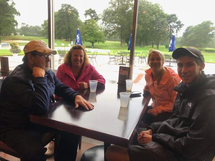 a group of people are sitting at a table in front of a window
