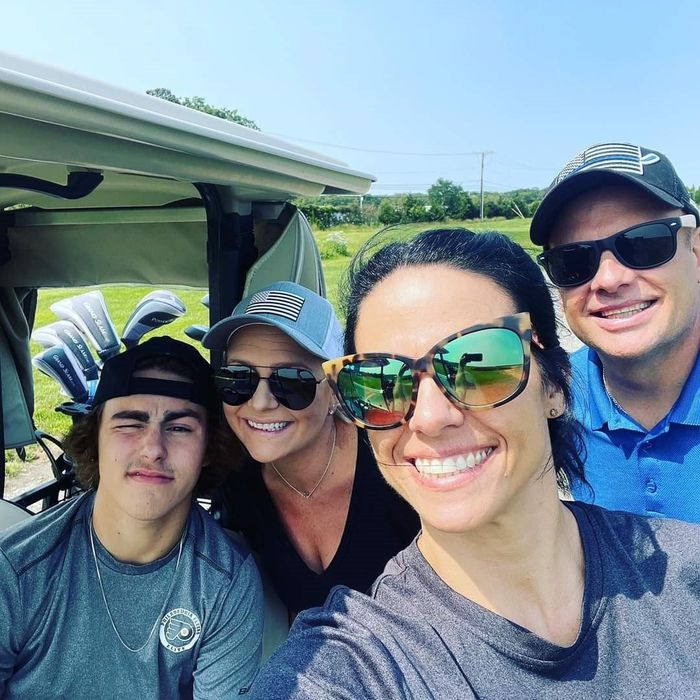 a group of people are posing for a picture in a golf cart .