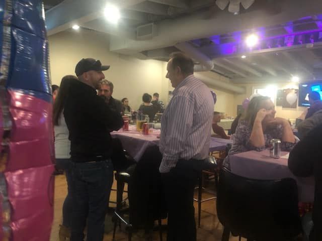 a group of people are sitting at tables in a room .