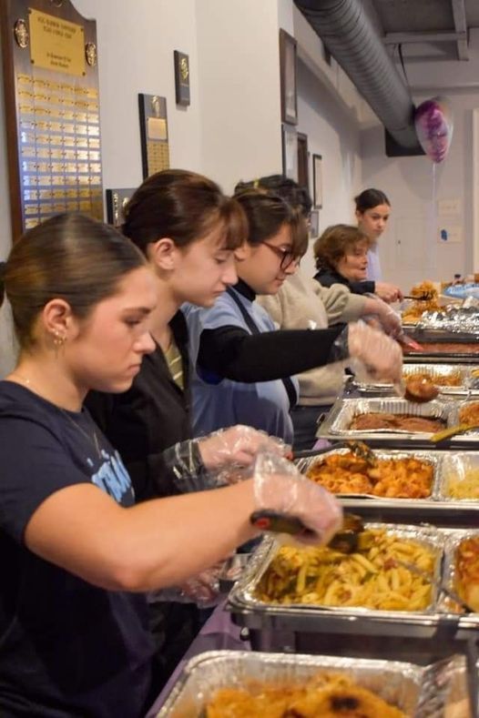 a group of women are preparing food at a buffet line .