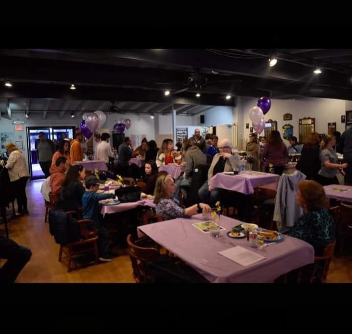 a large group of people are sitting at tables in a room .
