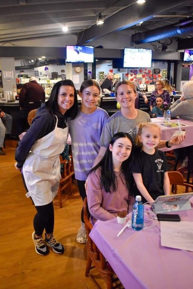 a group of women are posing for a picture in a restaurant .