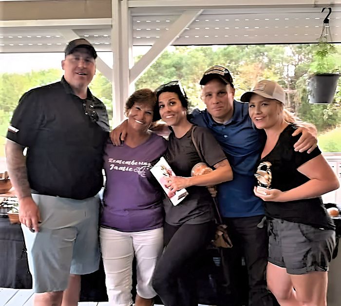 a group of people posing for a picture with one woman wearing a purple shirt