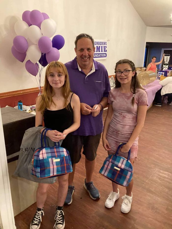 a man and two girls are standing next to each other in a room with balloons .