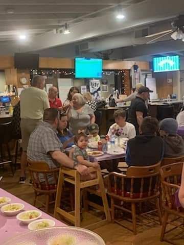 a group of people are sitting at tables in a restaurant .