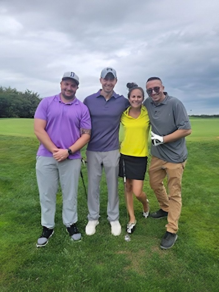 a group of people are posing for a picture on a golf course .